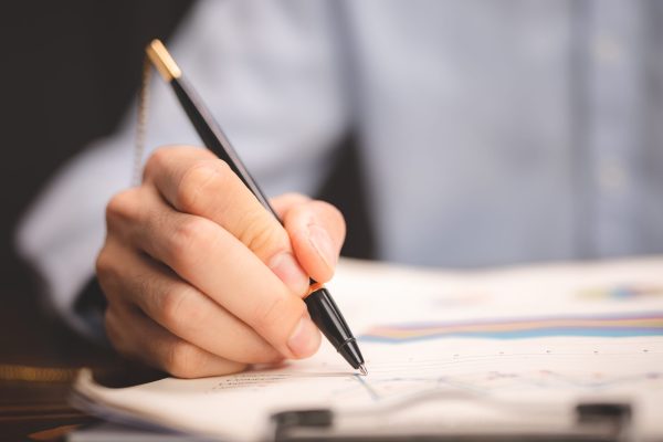 business of insurance client feedback service concept, businessman are work on marketing management business lawyer document approval concept, professional businessman using a pen to signing signature for deal acceptance a contract paperwork or finance agreement in modern office